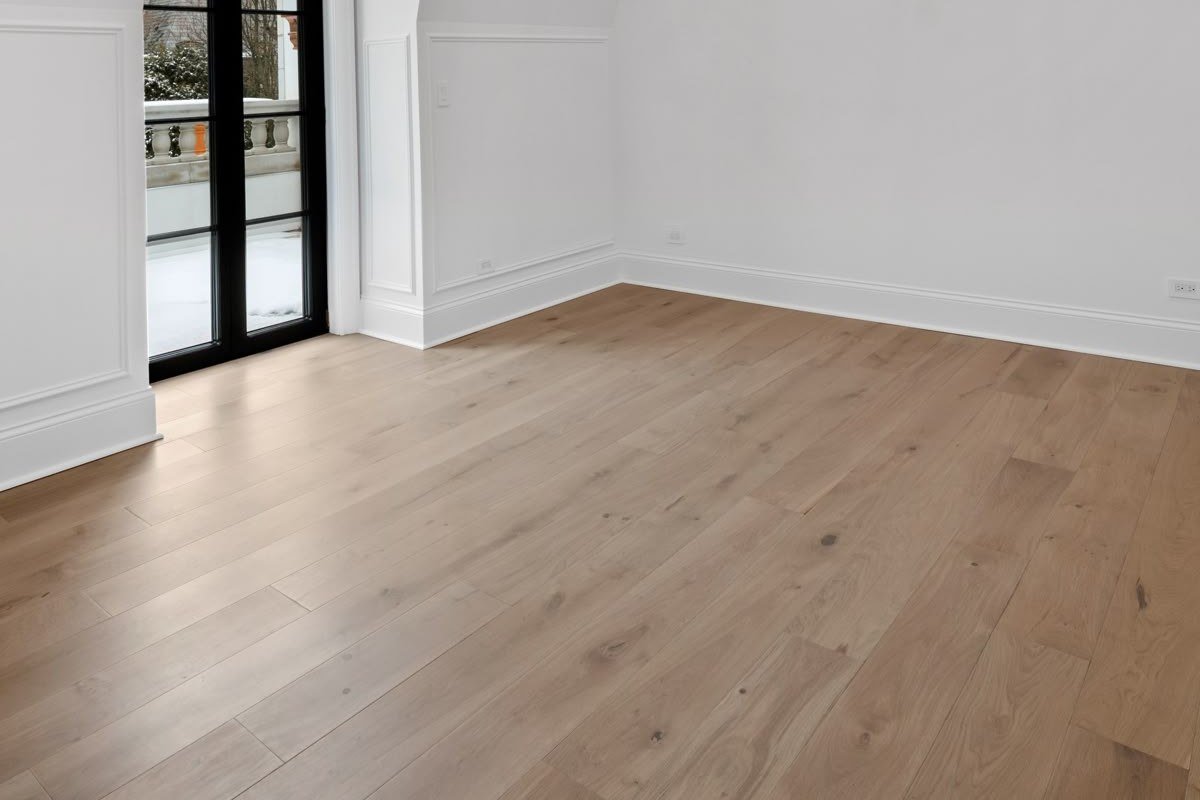 Light hardwood-look floor in a white room with a black-framed door and wall paneling