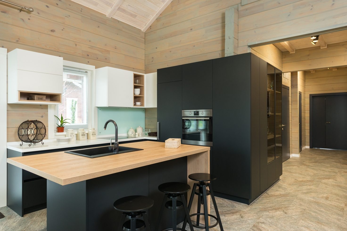 Kitchen with a dark tall cabinet wall and a butcher-block island